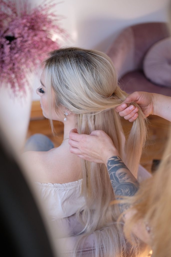 Step 1 eines geflochtenen Zopfs: Die Haare rechts und links jeweils bis zum Ohr abteilen