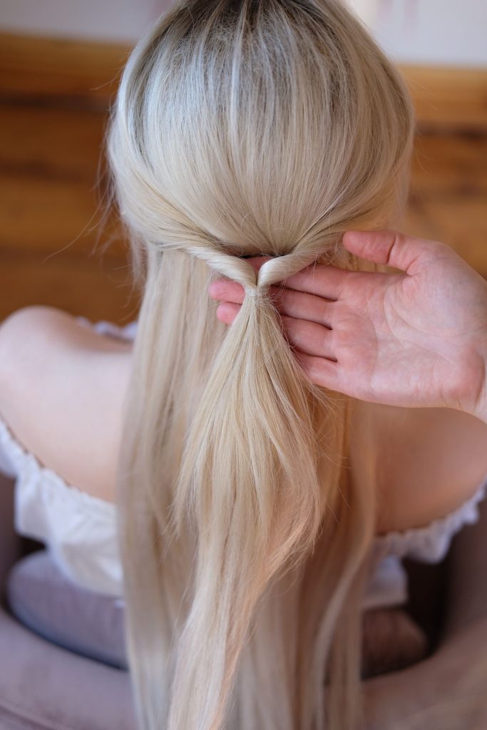 Step 3 des geflochtenen Zopfs ist ein Knoten im Haar, der die Basis der Frisur bildet
