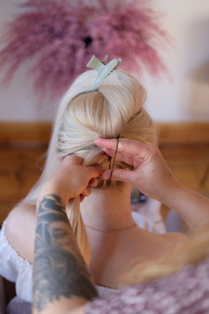 Die Haare im Nacken werden zu einem Zopf unterhalb des ersten Zopfs gebunden