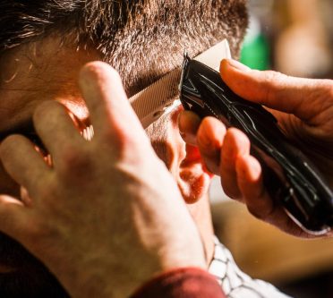 Herrenhaarschnitt mit einer Haarschneidemaschine über Kamm