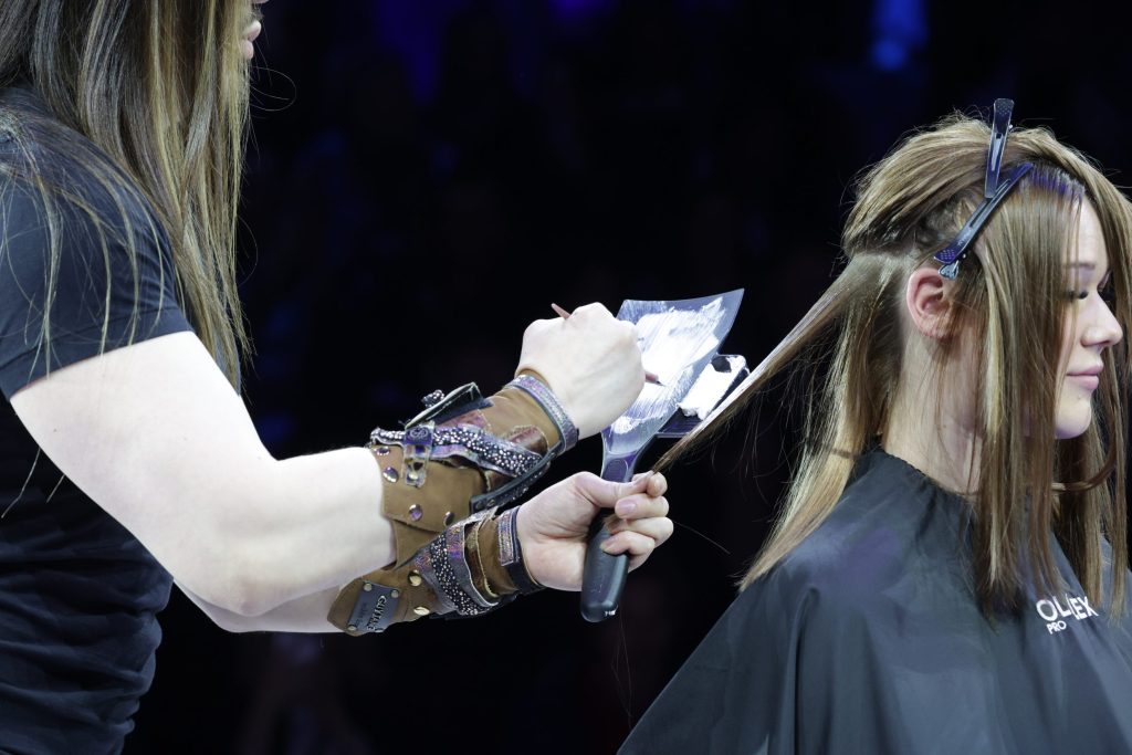 Guy Tang trägt die Blondierung mit einem Board auf