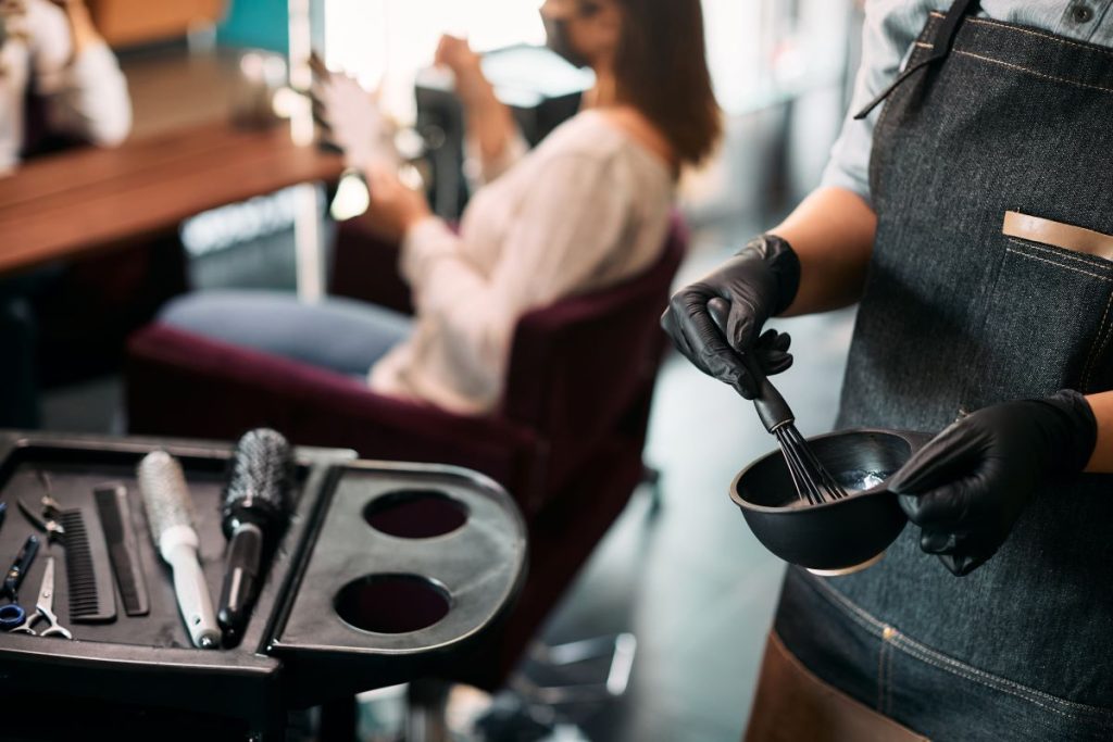 Mindestlohn Friseure im Fokus - das gilt 2025 2 In Salon bereitet eine Friseurin das Haarfärbemittel vor Mindestlohn Friseure