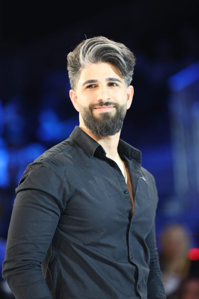 Ein grauhaariger Mann mit Kurzhaarfrisur, Haartolle und Vollbart