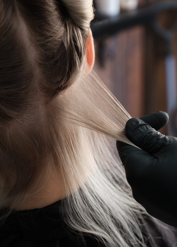 Airtouch: Die ultimative Haartechnik für einzigartig, natürliche Strähnen 2025 2 Eine behandschuhte Hand hält feine Haarsträhnen.