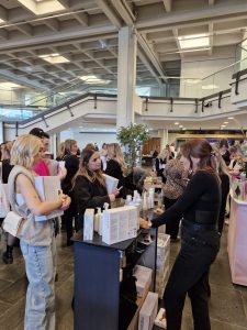 Foto von Stand im Foyer mit Besucherinnen