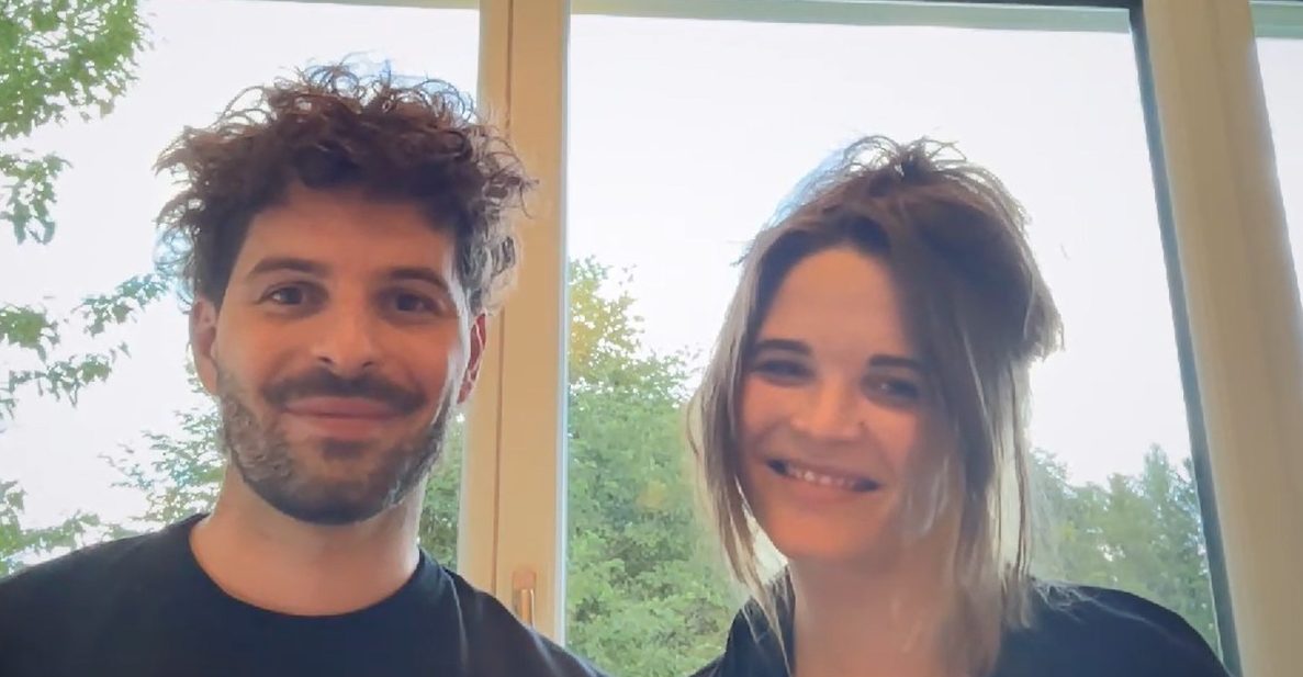 Konstantin und Theresa Empl vor einem Fenster mit Bäumen im Hintergrund