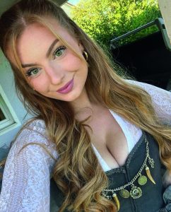 Das Bild zeigt eine Frau im Dirndl, mit langen, gewellten Haaren.