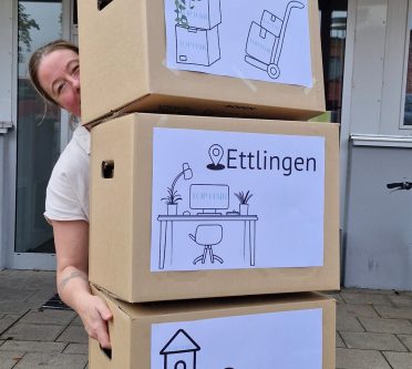 Frau trägt Umzugskartons
