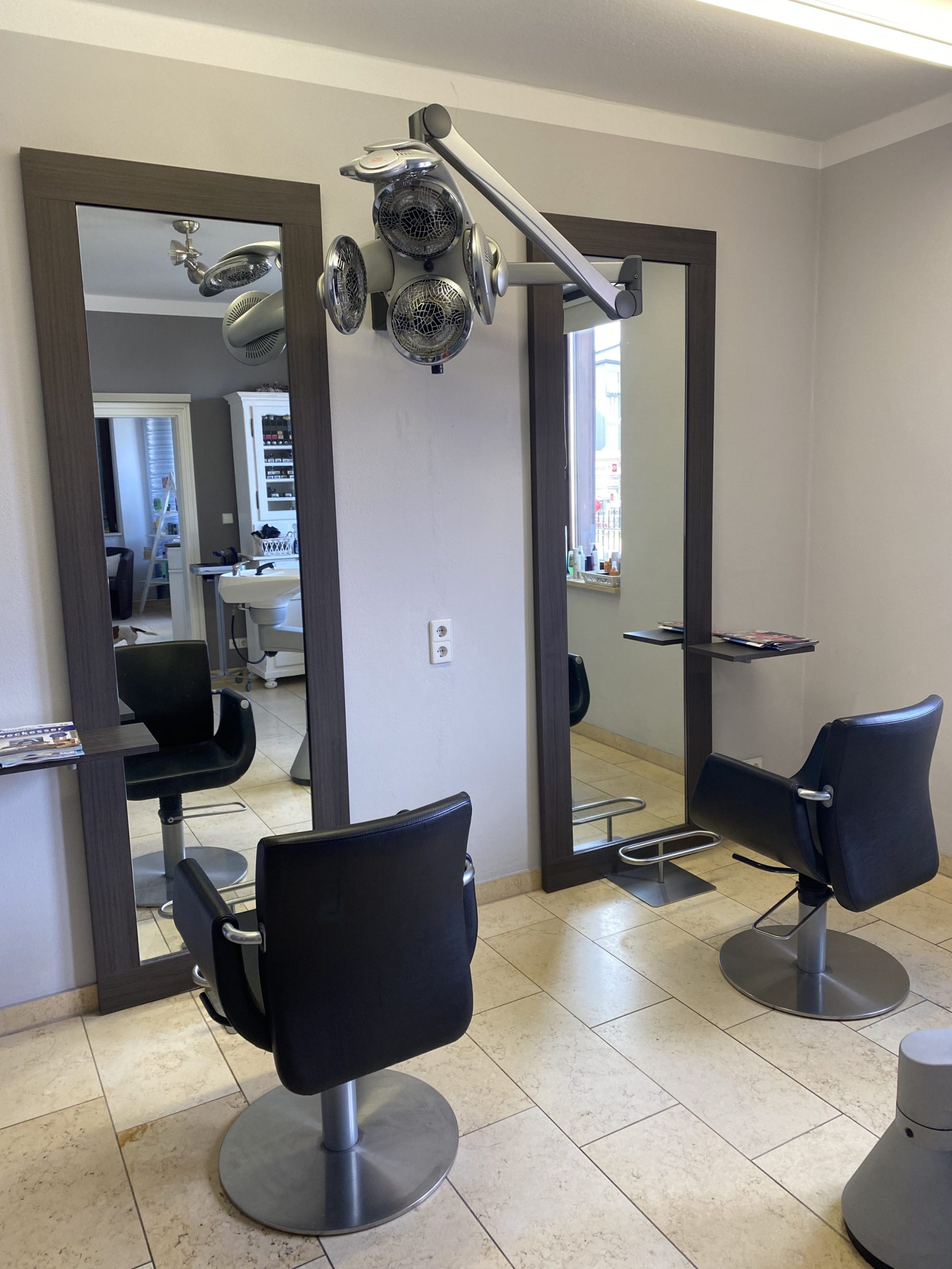Kassenbereich mit großem Display an der Wand eines Salons.