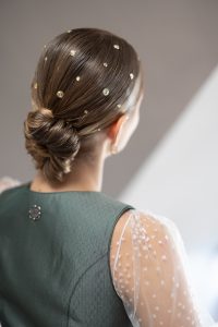 Das Bild zeigt eine Frau im Dirndl, mit einer Duttfrisur und Perlenschmuck.