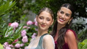 Das Bild zeigt zwei Frauen im Dirndl, mit einer sleeken Frisuren mit Scheitel.
