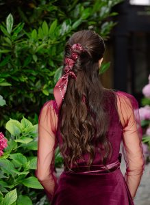 Das Bild zeigt eine Frau im Dirndl, mit einer Flechtfrisur und Tuch im Haar.