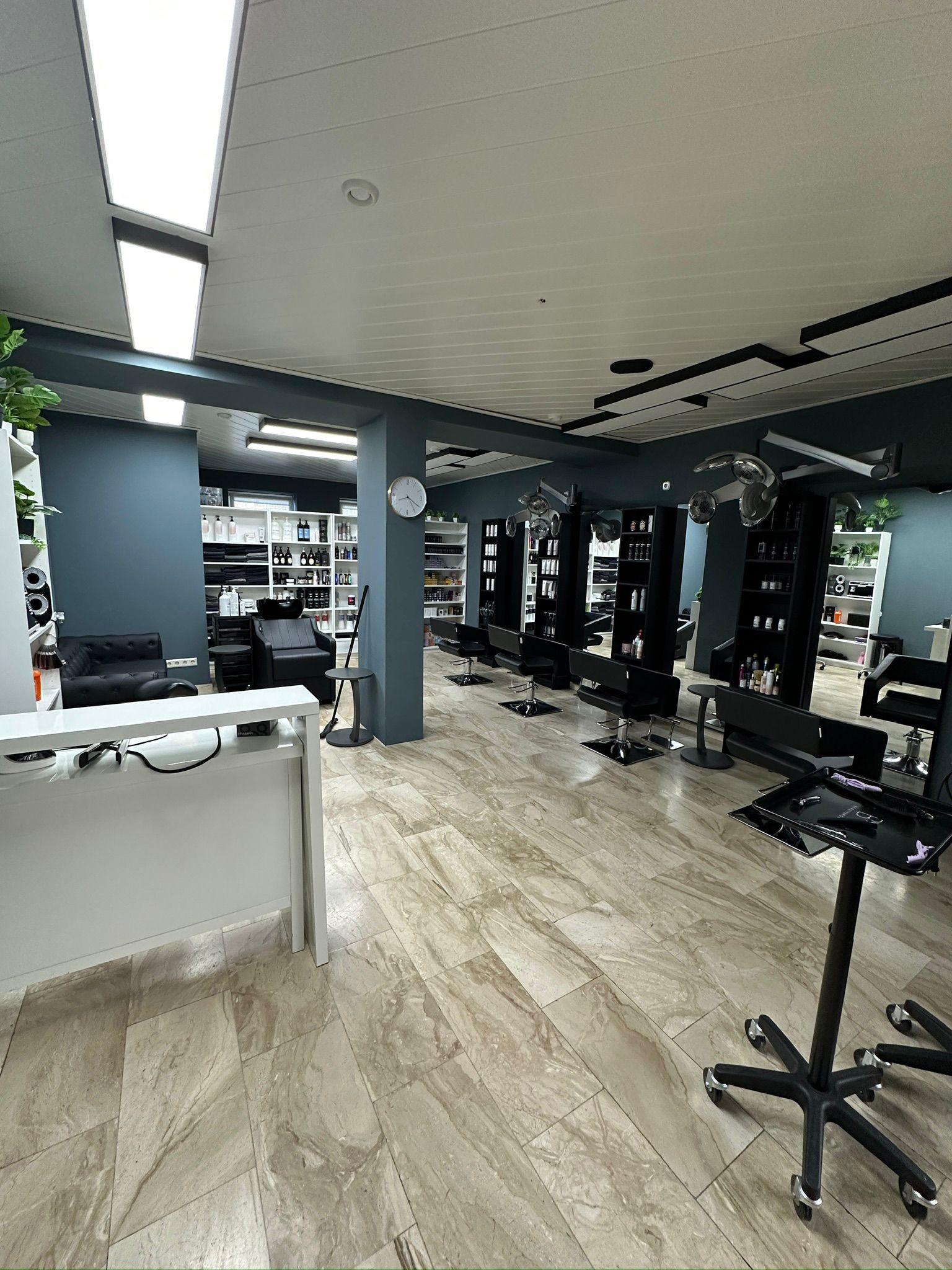 Kassenbereich mit großem Display an der Wand eines Salons.