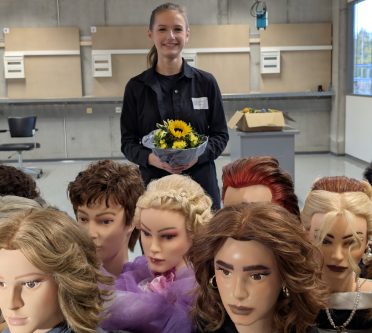 DMH Friseurhandwerk Kaiserslautern 26.10.2025 Platz 1 Lilly Kalterherberg_V2 Junge Friseurin siegt bei Wettbewerb, hält Blumen in der Hand.