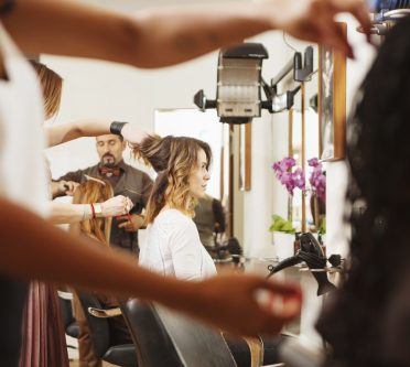 Stylischer Friseursalon in vollem Gange mit Kunden und Stylisten bei der Arbeit