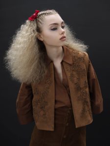 Eine blonde, voluminös gestylte Langhaarfrisur mit Flechtelementen