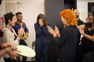 Eine Friseurin schlägt sich die Hände vors Gesicht, eine andere applaudiert