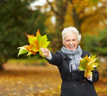 shutterstock-46203277-_Robert Kneschke Ältere Frau beim Herbstspaziergang mit Blättern in der Hand