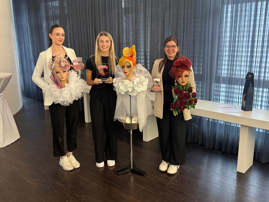 Die drei Bestplatzierten präsentieren sich mit ihrer Arbeit, einer aufwändigen Steckfrisur am Medium.