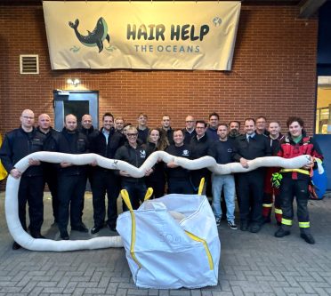 Feuerwehrmänner halten einen Schlauch, der mit Haaren gefüllt ist