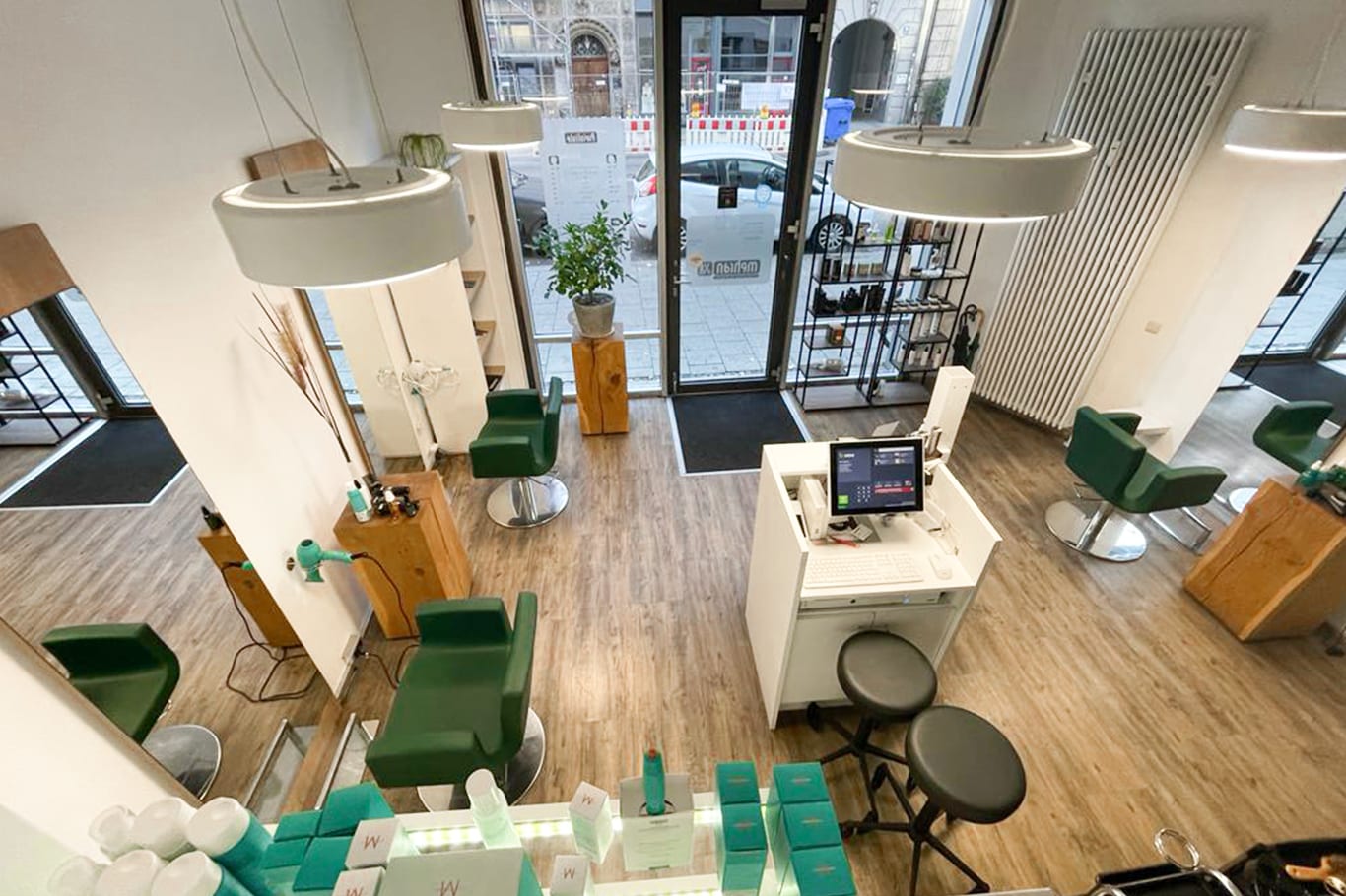 Kassenbereich mit großem Display an der Wand eines Salons.