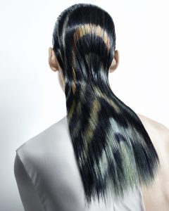 Man sieht eine glatte Langhaar-Frisur von hinten, mit grafischen Farbeffekten