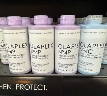 Man sieht Flaschen des Reparaturshampoos Olaplex im Regal