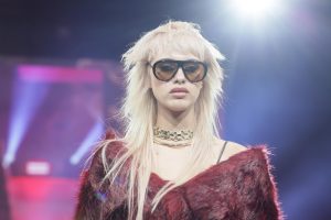 Workshop-Trend Stufen 4 Frau mit blondem, stark gestuftem Haar und Sonnenbrille auf einem Laufsteg