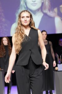 Workshop Stage 2026 18 Frau mit blondem, langem, gewelltem Haar auf einem Laufsteg