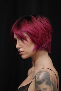 Workshop Stage 2026 48 Frau mit magentafarbenem, stufigen Haarschnitt auf einem Laufsteg