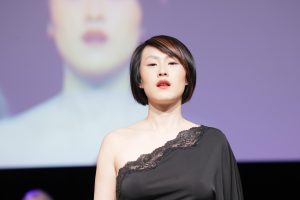 Workshop Stage 2026 45 Frau mit schwarz-rotem Bob auf einem Laufsteg