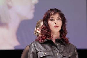 Workshop-Trend Stufen 9 Frau mit weinrotem, gewelltem Haar auf einem Laufsteg