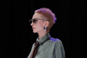 Workshop Stage 2026 21 Frau mit sehr kurzem Haar in Flieder- und Kupfertönen auf einem Laufsteg