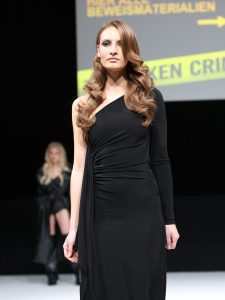 Workshop Stage 2026 37 Frau mit braunem, langem, gewelltem Haar auf einem Laufsteg