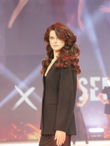 Workshop-Trend Heritage Chic 2 Frau mit braunem, langem, gewelltem Haar auf einem Laufsteg