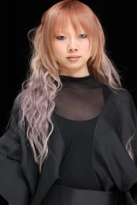 Workshop Stage 2026 34 Model mit kupfer-fliederfarbenem Langhaar auf einem Laufsteg