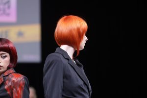 Workshop-Trend Bob 6 Eine Frau mit leuchtend kupferrotem Bob auf einer Bühne