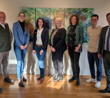 Eine Gruppe schick gekleideter Menschen, die für ein Foto in die Kamera lächeln