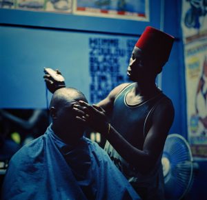 Ausstellung Haar - Macht - Lust 2 Ein Mann in einem Barbershop, dem gerade die Haare mit der Maschine geschnitten werden