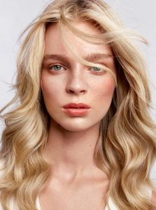 Trend-Kollektion Label.M 12 Eine Frau mit langem, gestuften blonden Haar, wellig bewegt gestylt