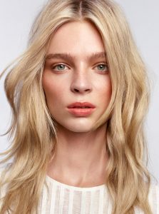 Trend-Kollektion Label.M 11 Eine Frau mit langem, gestuften blonden Haar, wellig gestylt