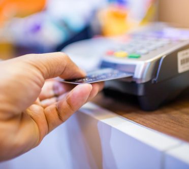 Hand steckt Bankkarte in Lesegerät