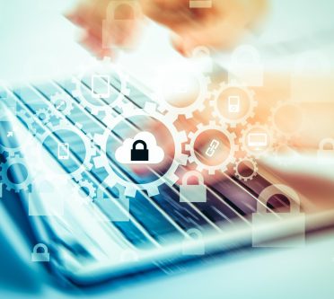 Laptoptastatur, auf der Hände tippen, Symbole, wie Vorhängeschloss, Zahnrad schweben darüber