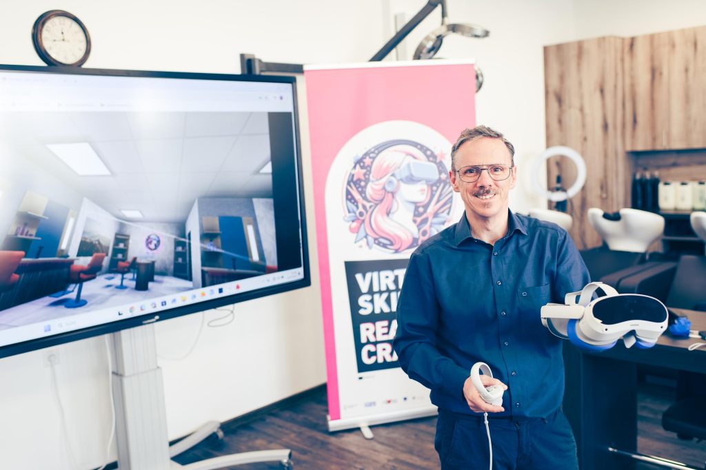 Friseurausbildung als Mixed Reality 4 Das Bild zeigt den Lehrer Rietzscher, der eine VR-Brille hochhält