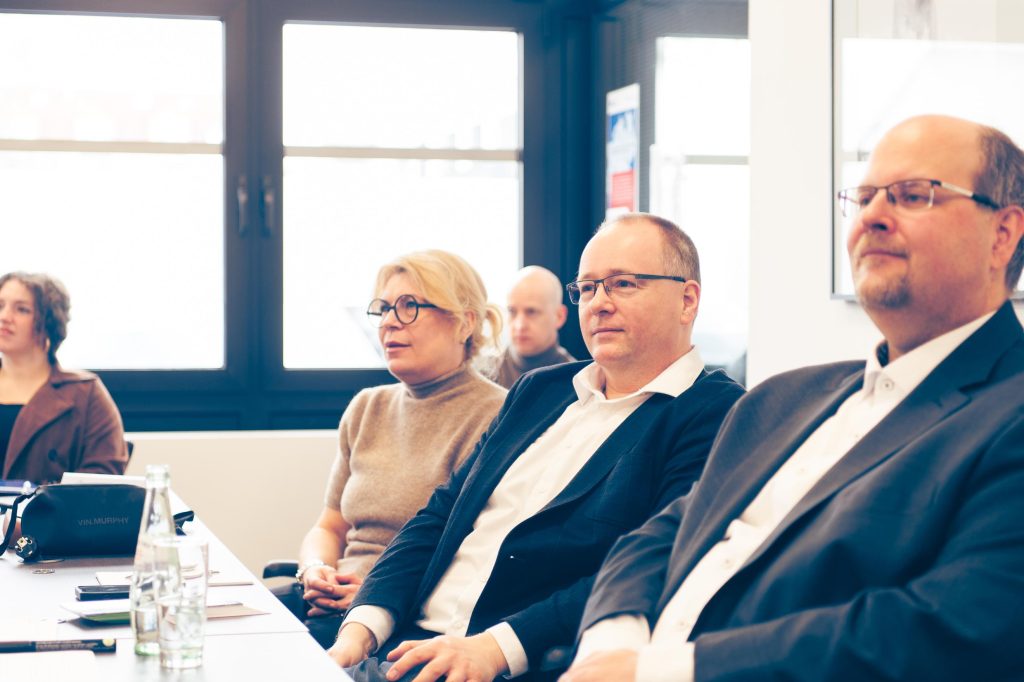 Friseurausbildung als Mixed Reality 5 Das Foto zeigt OM Zdenka Schwabbauer, Dennis Pusch (Leiter BBZ Märkischer Kreis) und Dominik Lux von der EU-Geschäftsstelle, die nebeneinander an einem Tisch sitzen