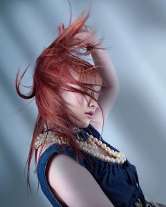 Kollektion_Mood_Tracey_Ann_Smith 8 Ein Model mit fliegendem, kupferfarbenem Langhaar
