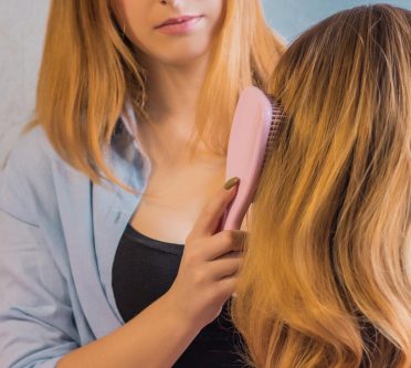 Frau bürstet Perücke