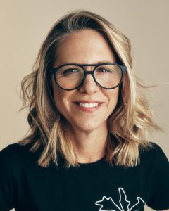 Trend Aveda 22 Schulterlanges Haar mit blonden Highlights und dunklerem Ansatz, wellig zur Seite gestylt