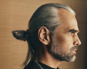 Trend Aveda 17 Graues Haar mit sleek nach hinten gestylten Seitenpartien und kleinem Dutt im Nacken