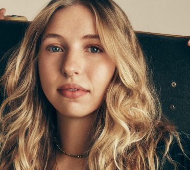 Langes blondes Haar mit dunklerem Ansatz und lässigen Wellen